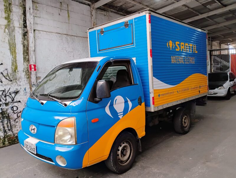 Caminhão com adesivação comercial na cabine e no baú